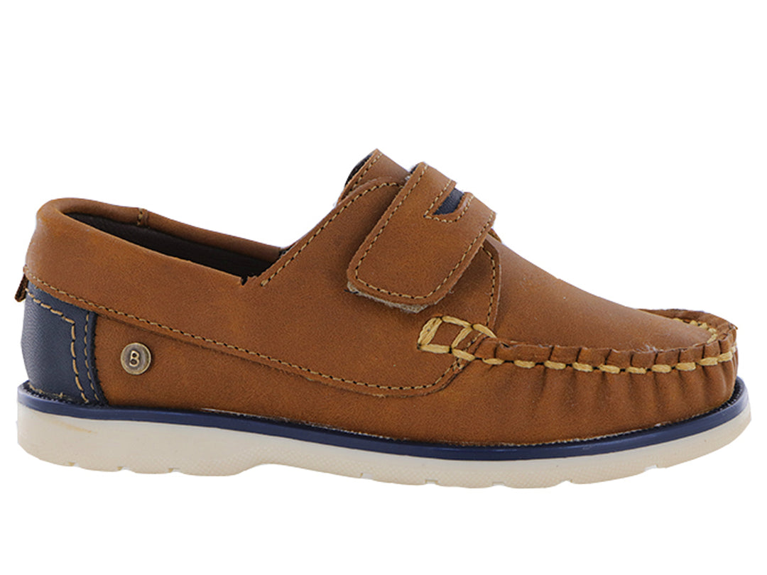 Zapatos tipo mocasín color tan para niño con correa ajustable y suela blanca con detalle azul.