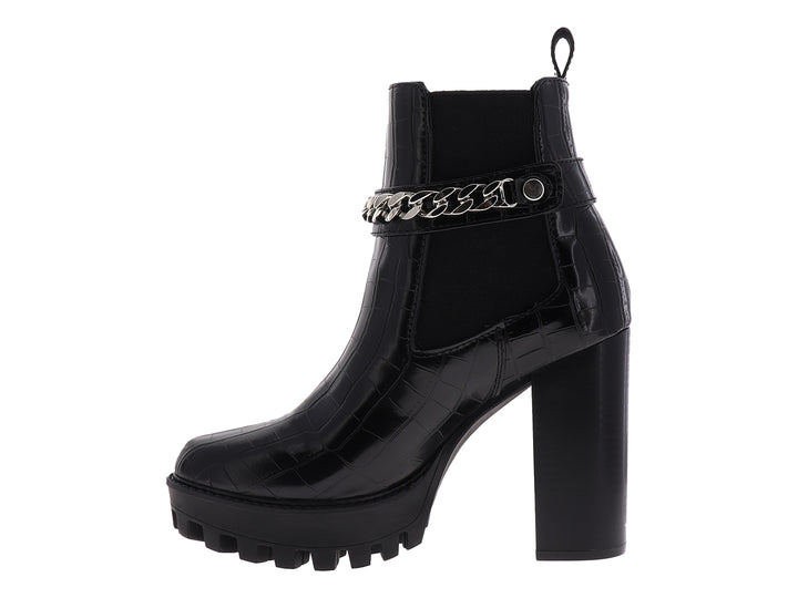 Botín negro para mujer con tacón alto, suela track y detalle de cadena plateada.