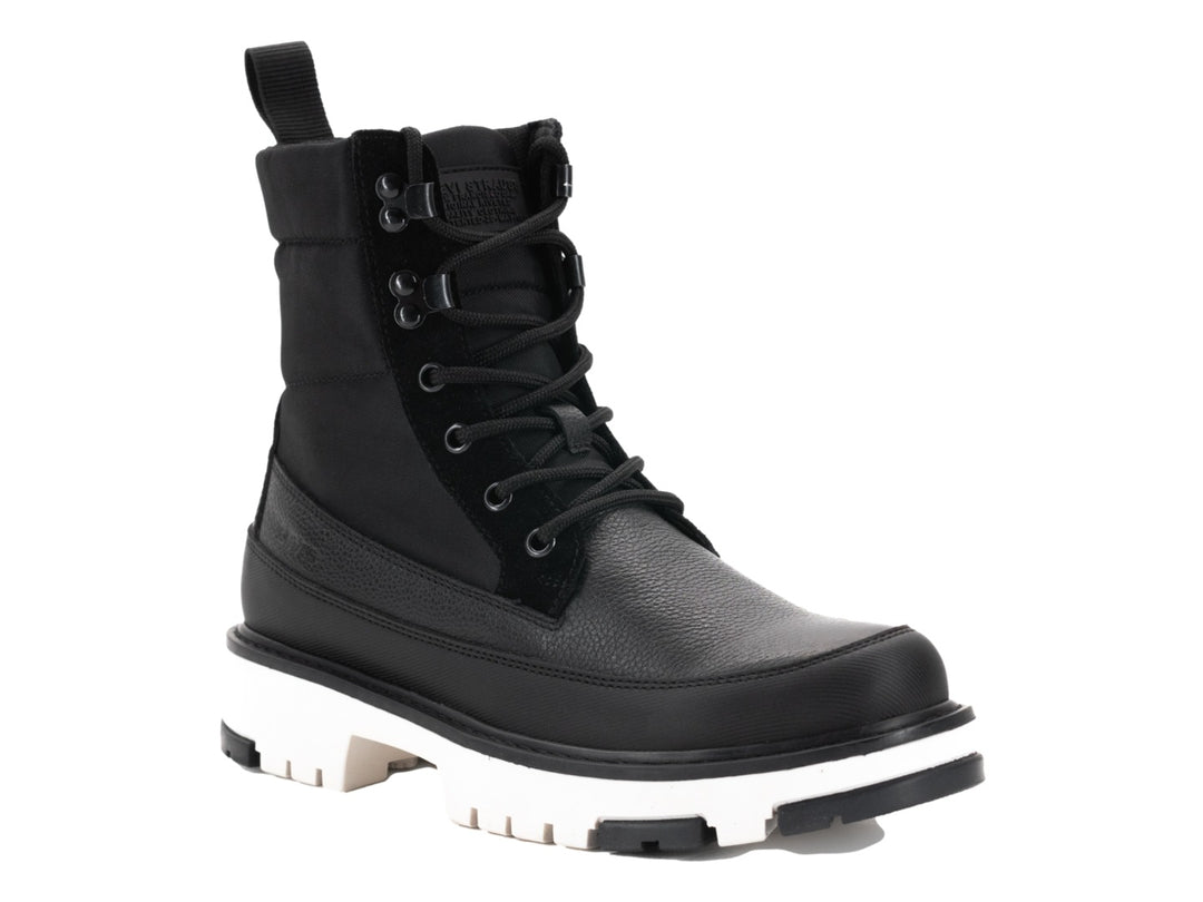 Bota negra de caña media con cordones y suela blanca gruesa de estilo track.