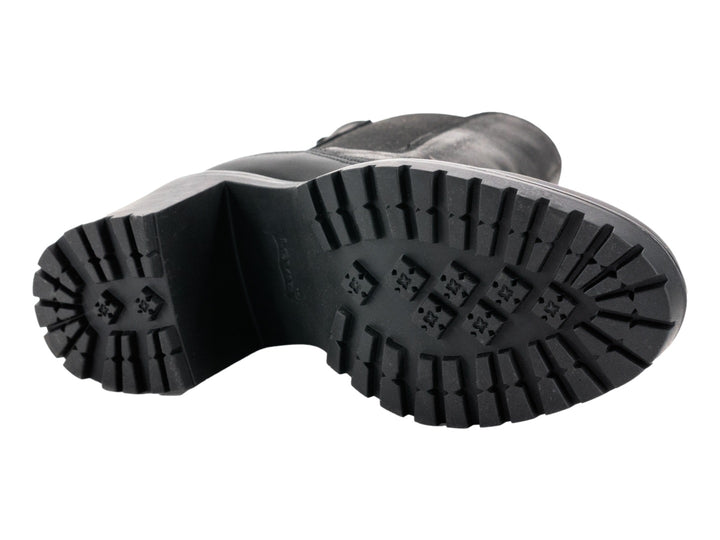 Bota negra de caña media con cordones y suela blanca gruesa de estilo track.