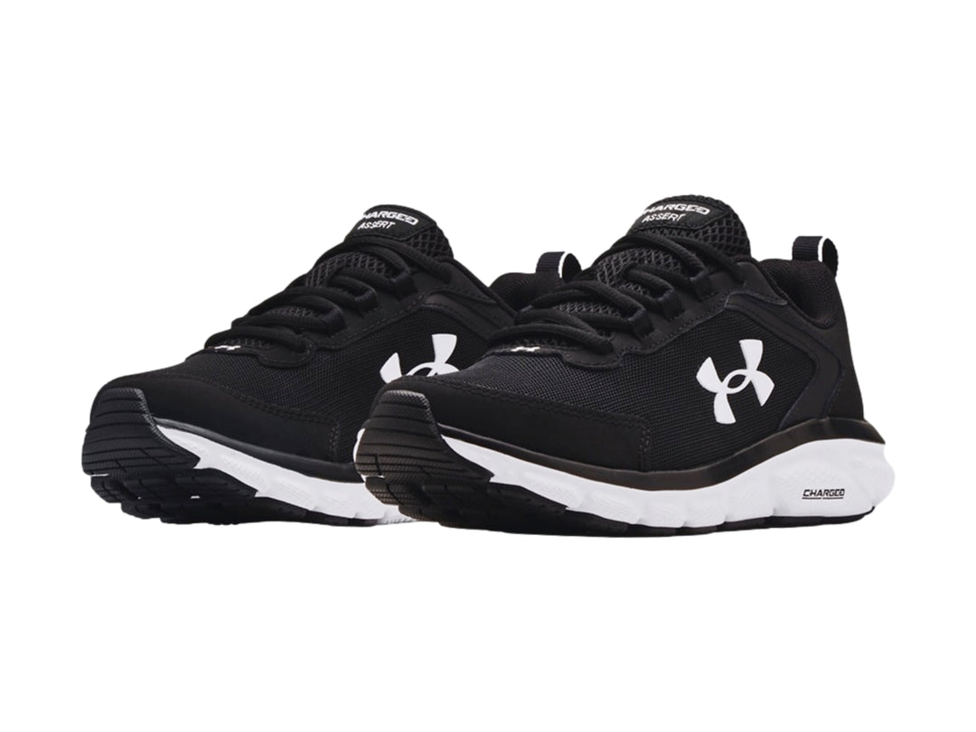 Tenis deportivos Under Armour color negro con suela blanca y logotipo blanco lateral.