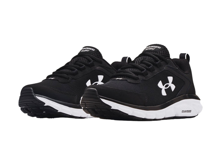 Tenis deportivos Under Armour color negro con suela blanca y logotipo blanco lateral.