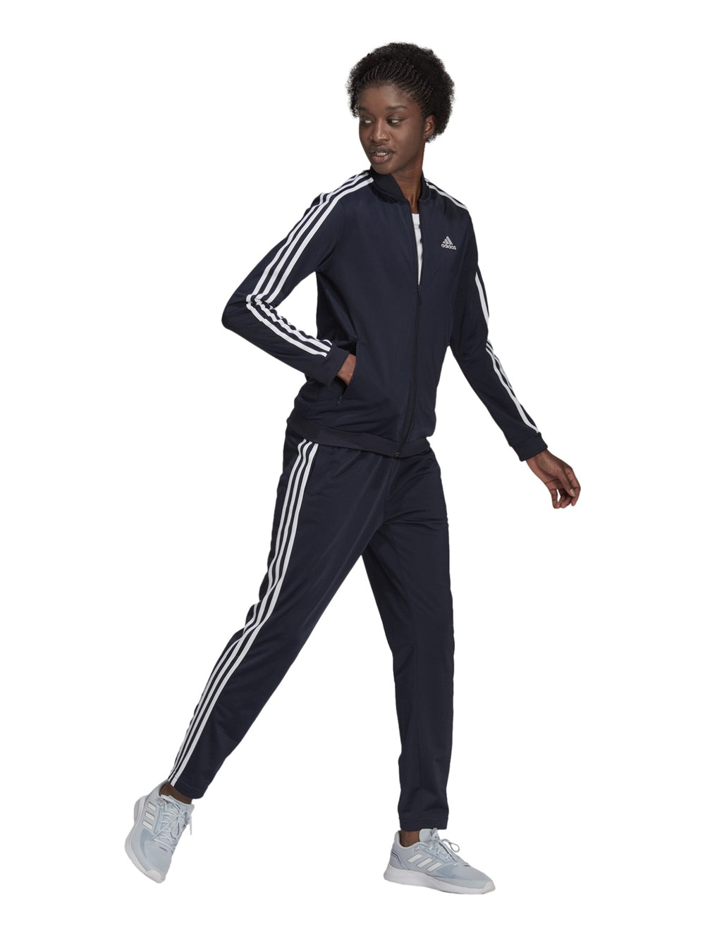 Mujer vistiendo conjunto deportivo Adidas azul marino oscuro con rayas blancas laterales.