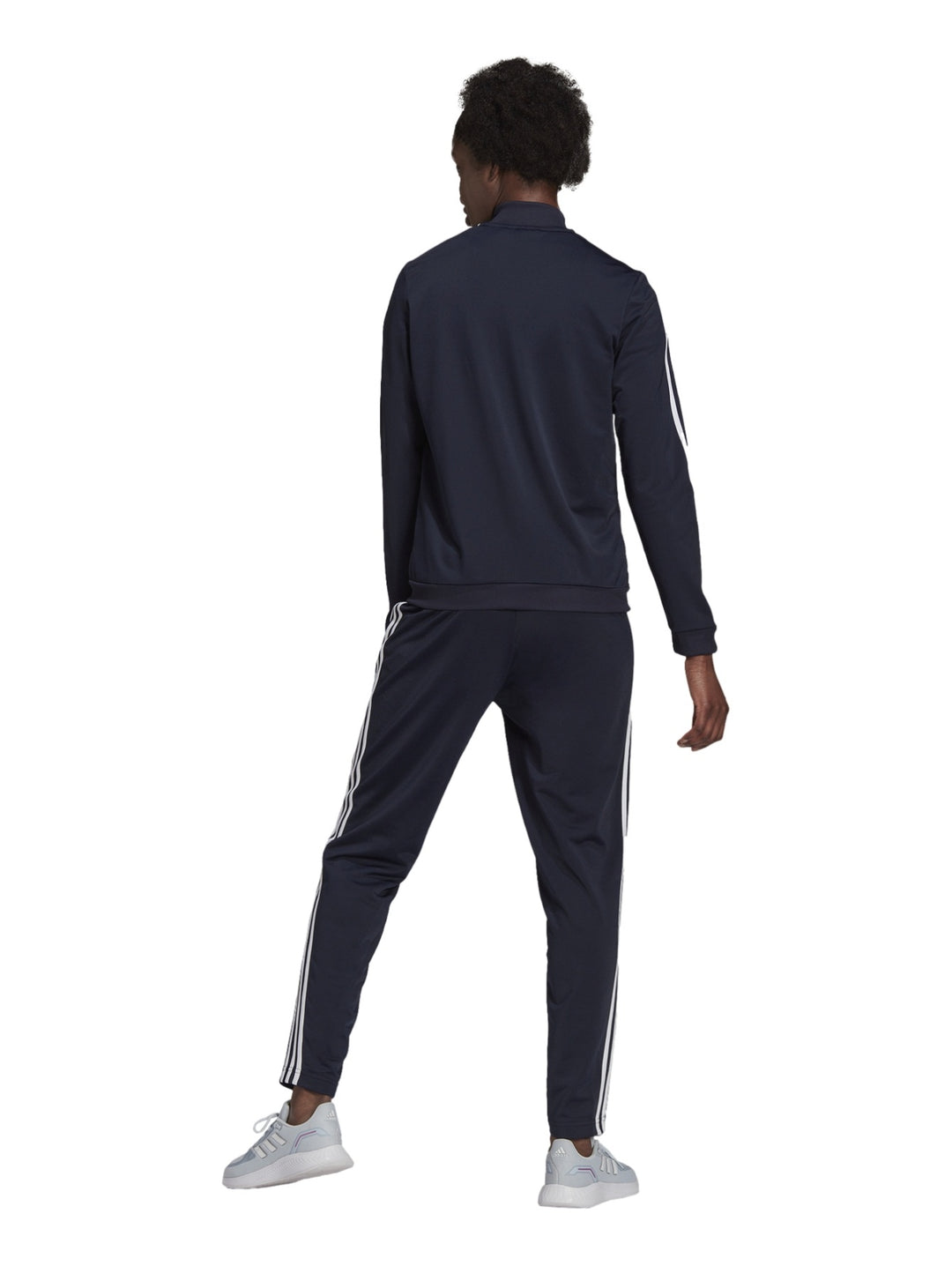Mujer vistiendo conjunto deportivo Adidas azul marino oscuro con rayas blancas laterales.
