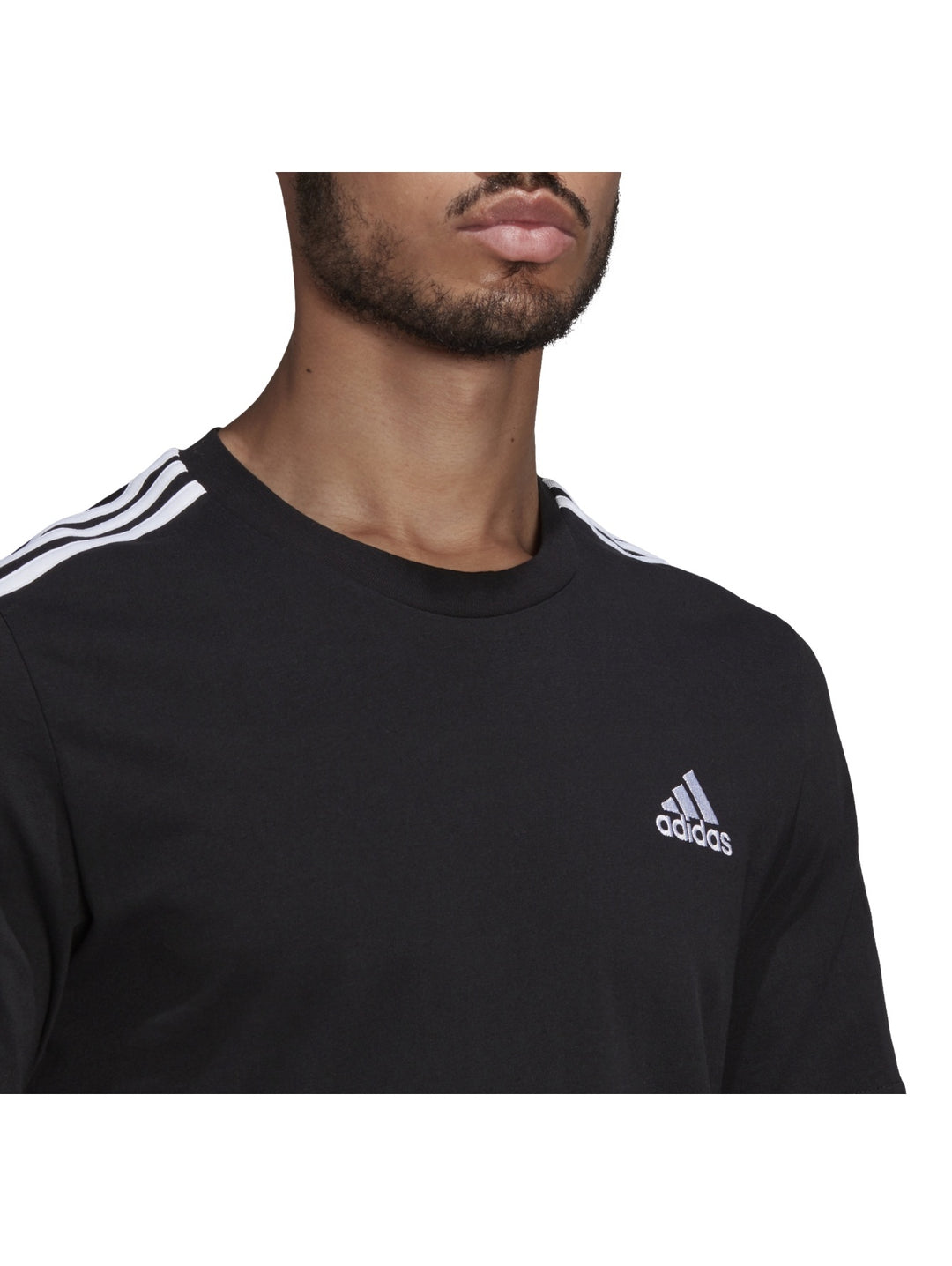 Hombre vistiendo playera deportiva Adidas color negro con tres franjas blancas en los hombros.