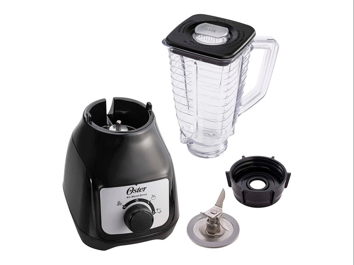 Licuadora Oster de color negro con vaso de plástico transparente y perilla de control frontal.