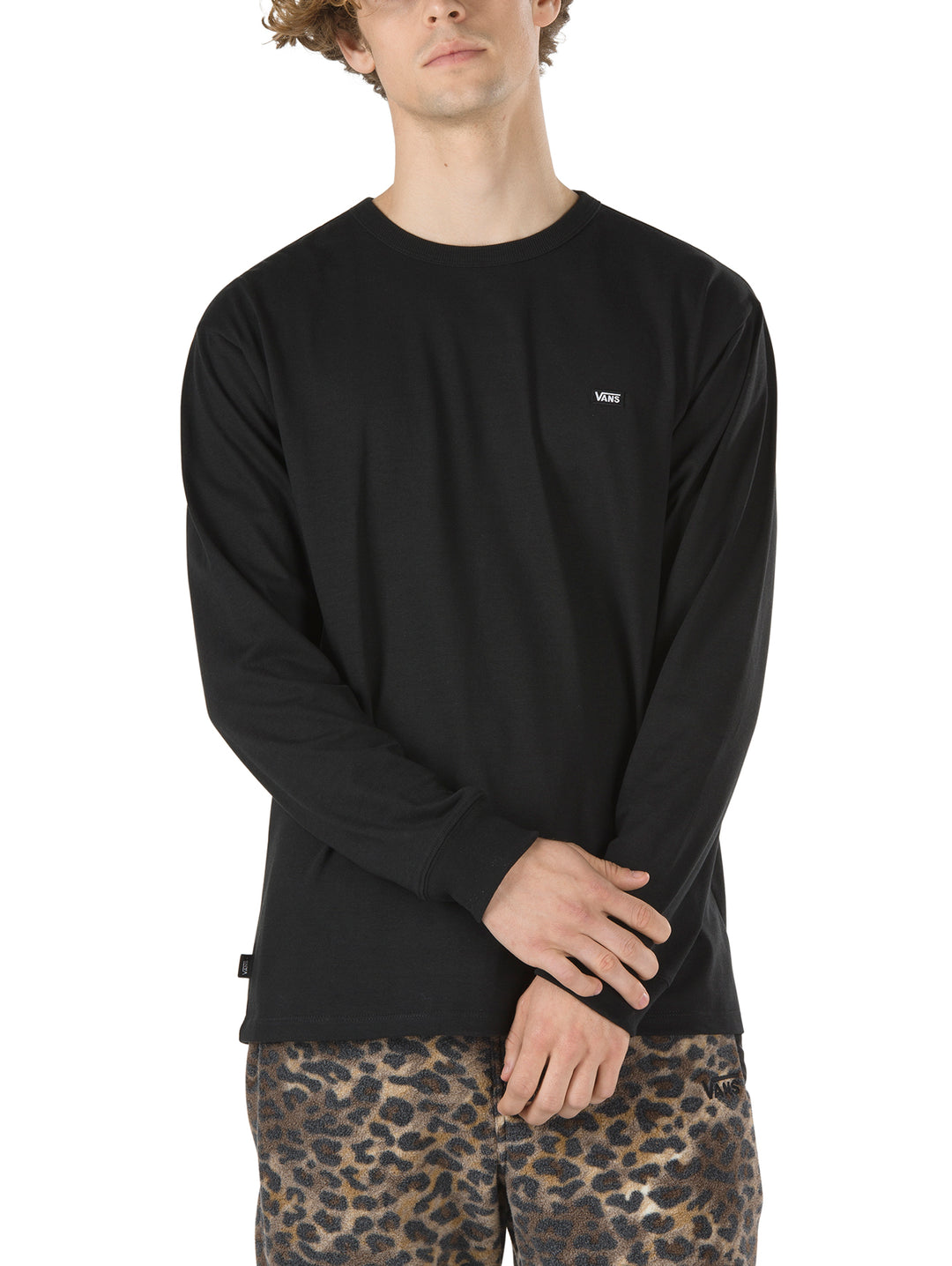 Hombre vistiendo playera negra de manga larga marca Vans con cuello redondo.