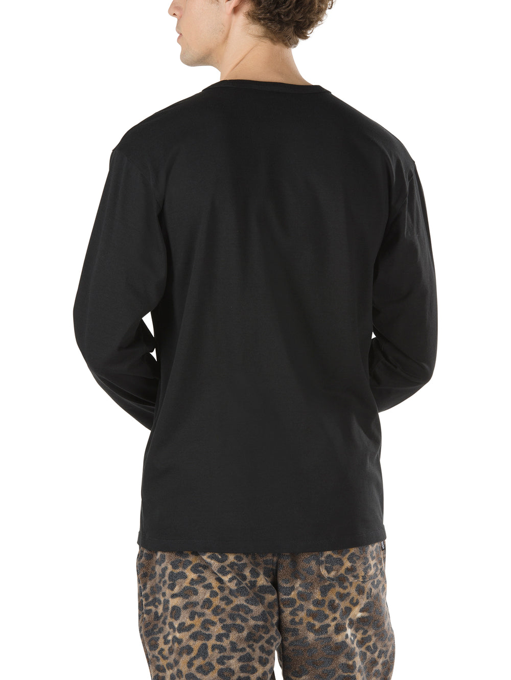 Hombre vistiendo playera negra de manga larga marca Vans con cuello redondo.