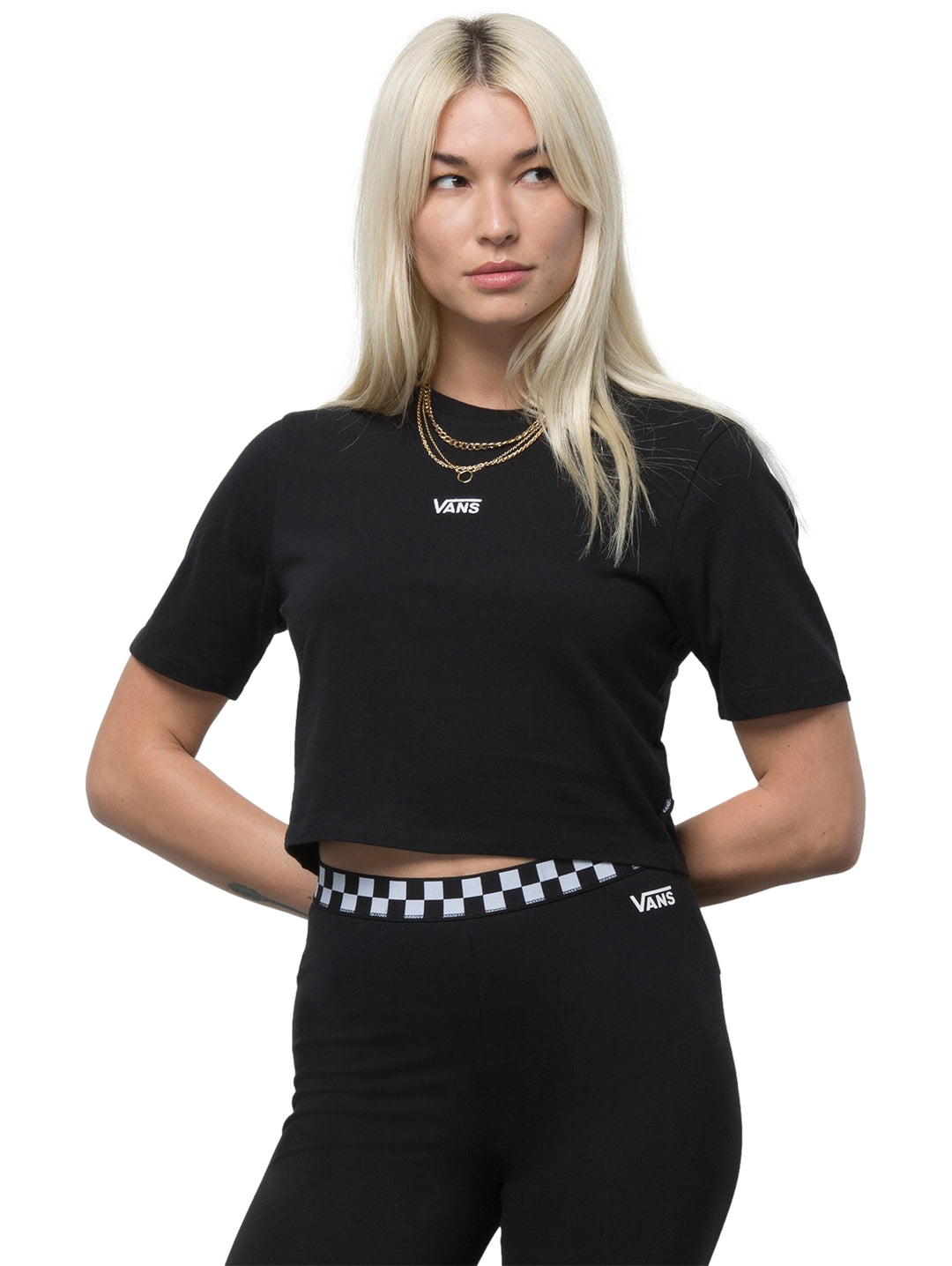 Mujer vistiendo una camiseta crop top color negro de marca Vans con cuello redondo y manga corta.