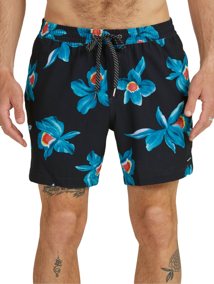Traje de baño boardshort negro con estampado de flores azules y naranjas.