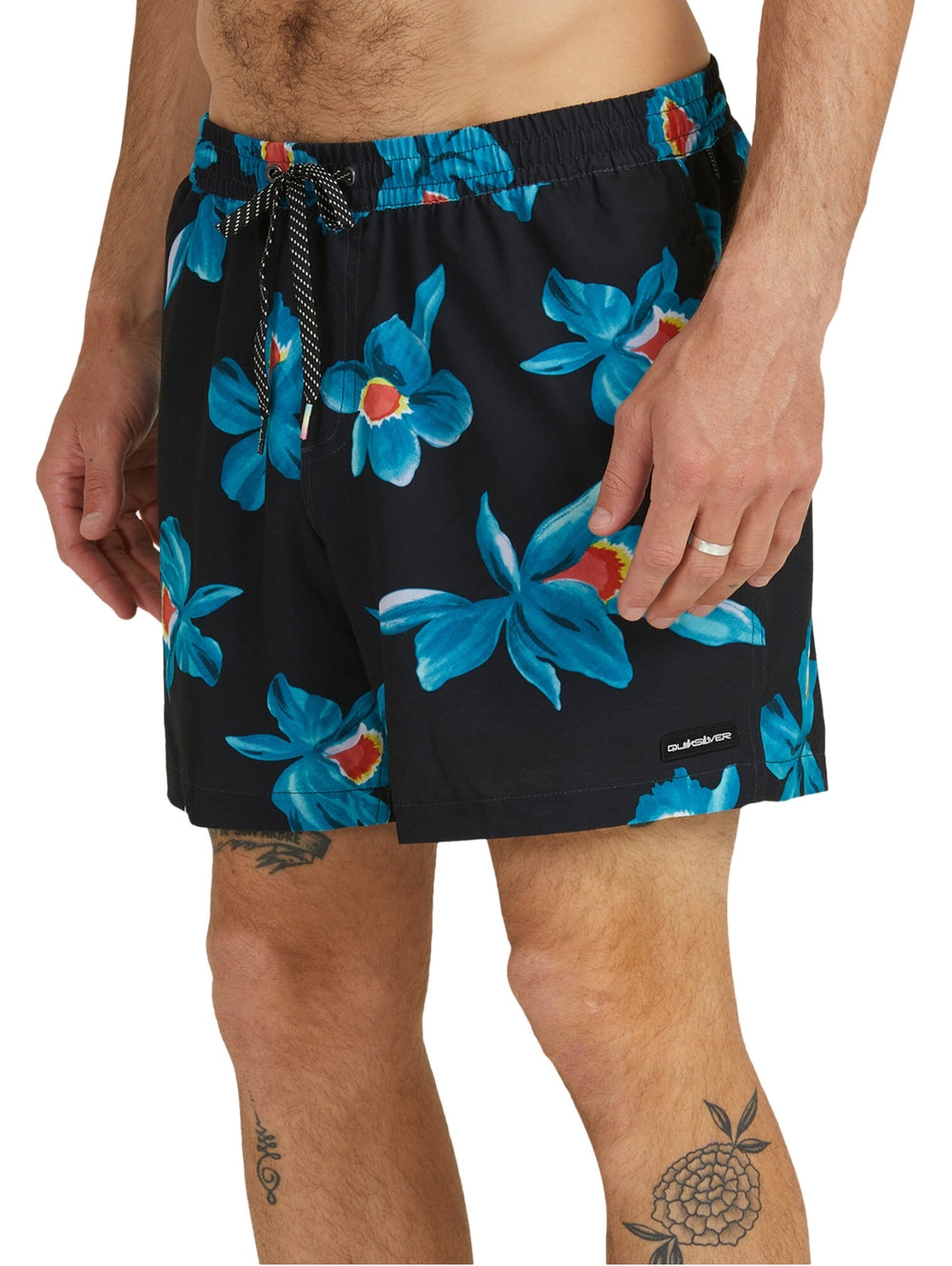 Traje de baño boardshort negro con estampado de flores azules y naranjas.
