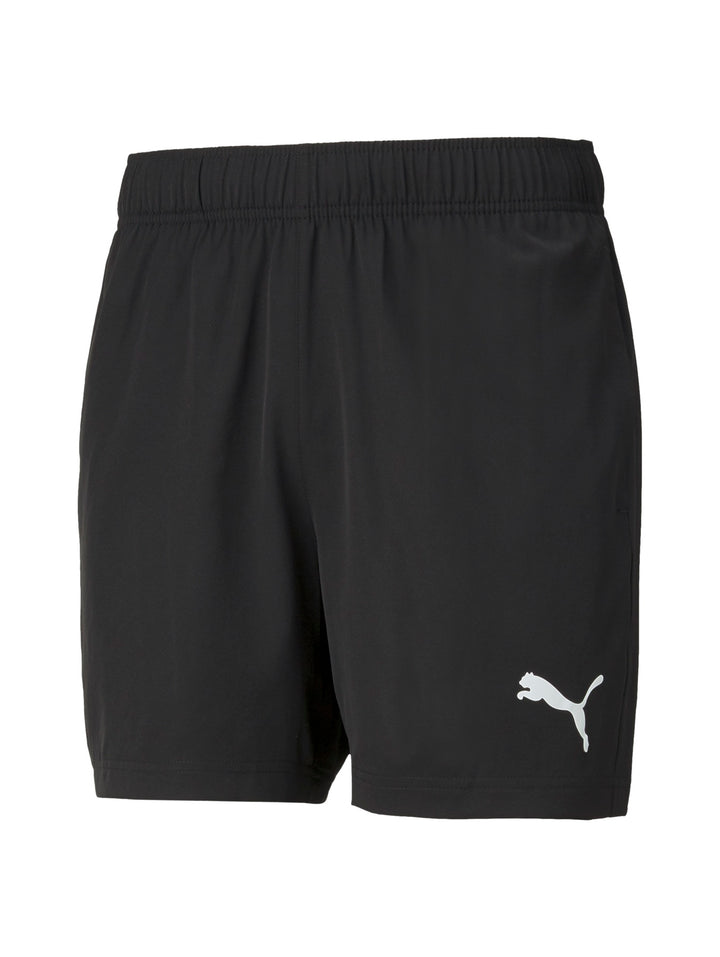 Hombre vistiendo shorts deportivos PUMA de color negro con logo blanco lateral.