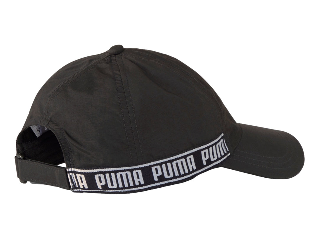 Gorra deportiva PUMA color negro con banda blanca lateral que muestra el nombre de la marca repetidamente.