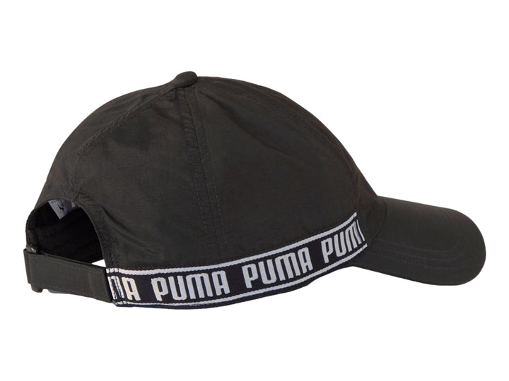Gorra deportiva PUMA color negro con banda blanca lateral que muestra el nombre de la marca repetidamente.