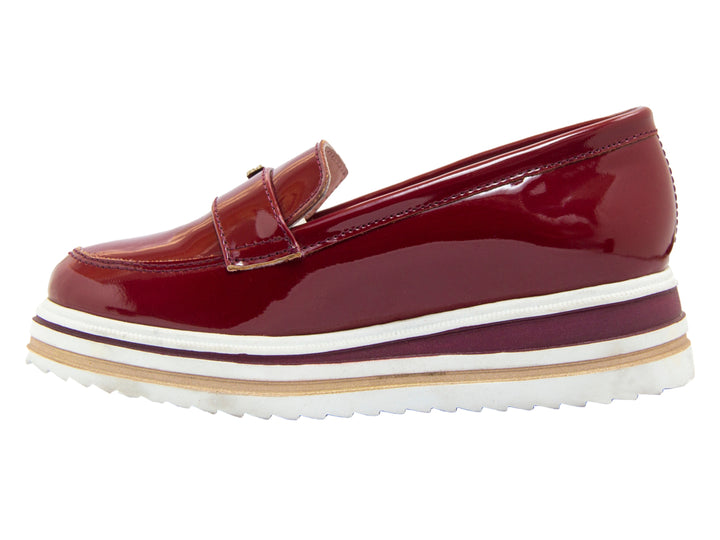 Zapato tipo mocasín para niño en charol color vino con suela blanca de plataforma gruesa.