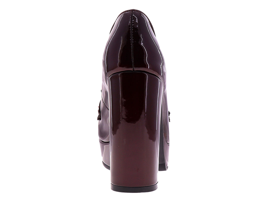 Zapato de tacón alto y plataforma color merlot brillante con detalle de hebilla plateada.