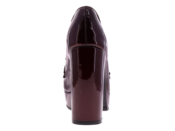 Zapato de tacón alto y plataforma color merlot brillante con detalle de hebilla plateada.