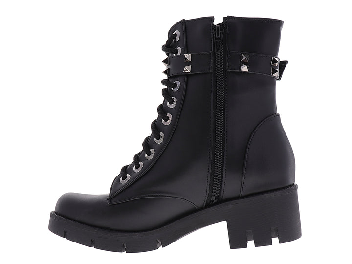 Bota negra de estilo militar con agujetas, suela track y correa con estoperoles plateados.