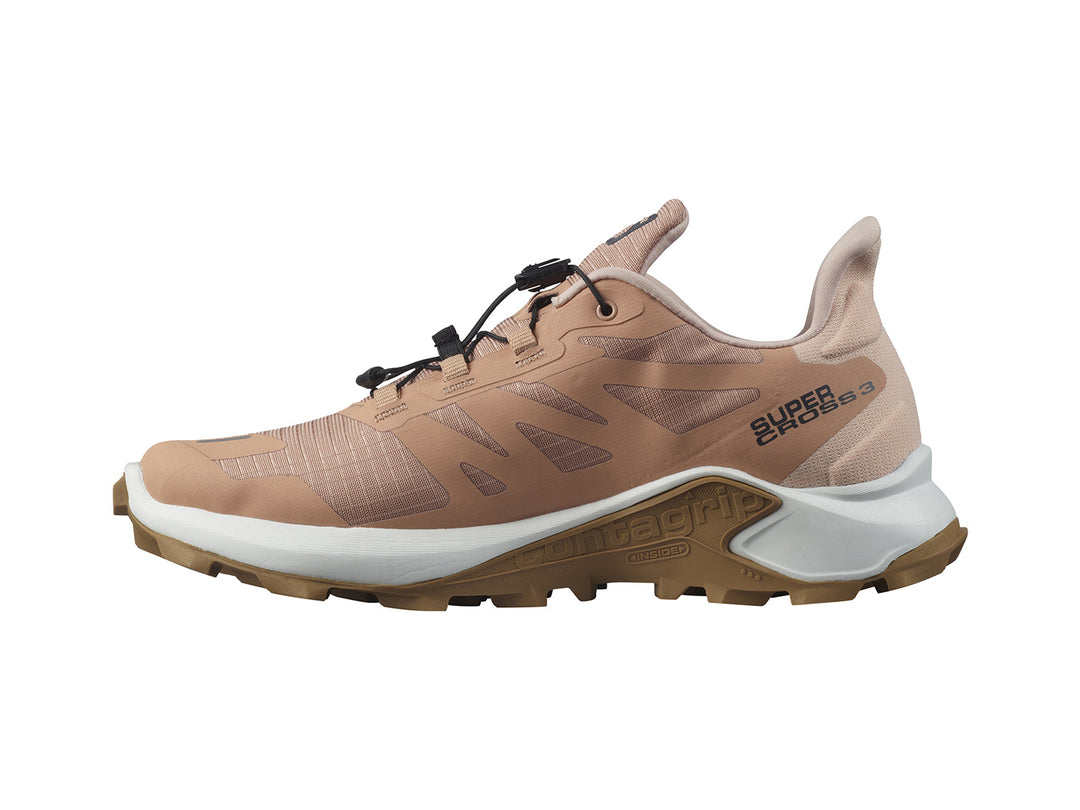 Tenis deportivos Salomon Supercross 3 en color beige con suela blanca y marrón.