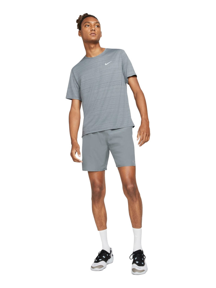 Hombre usando shorts deportivos Nike color gris humo y camiseta a juego.