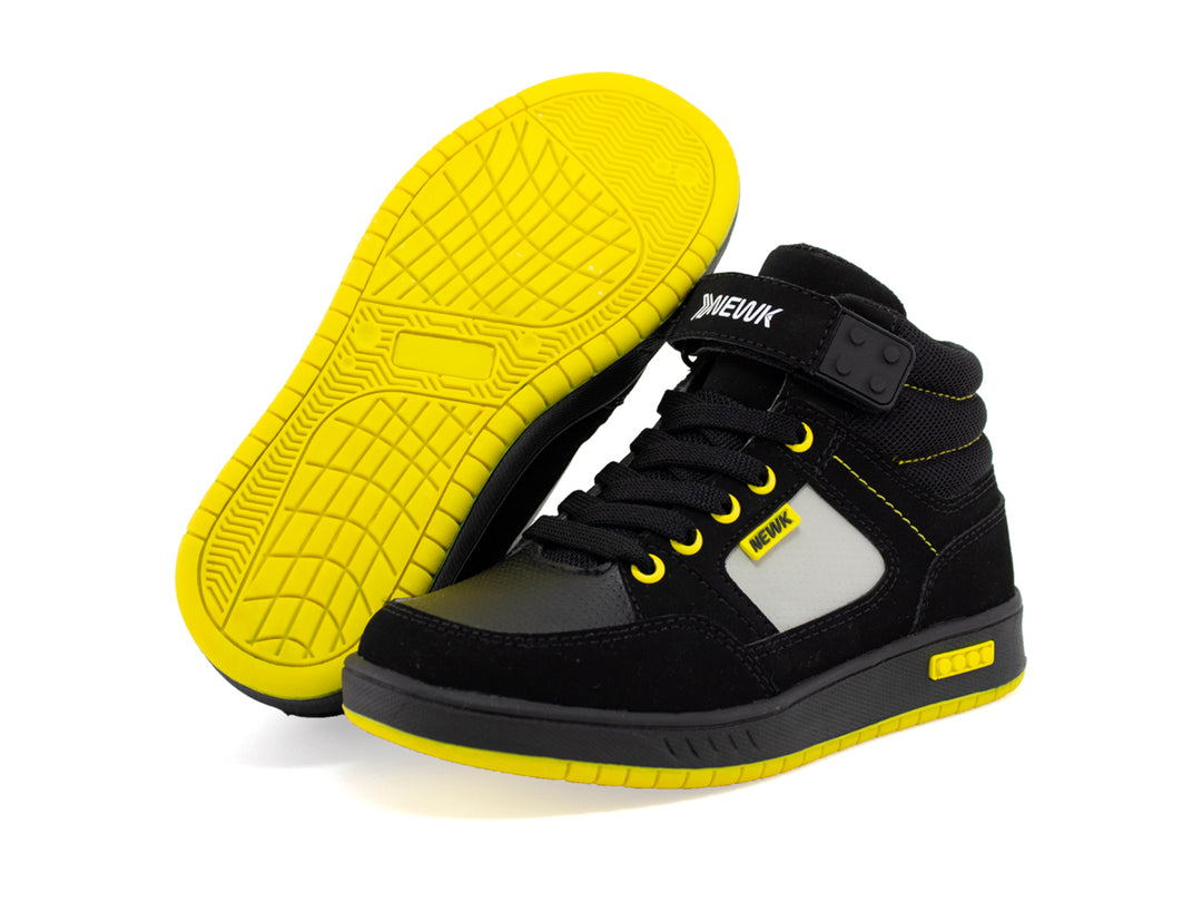 Tenis urbanos para niño marca NEWK en color negro con suela amarilla y detalles en blanco.