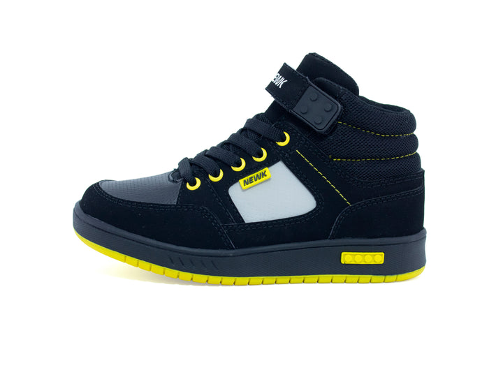 Tenis urbanos para niño marca NEWK en color negro con suela amarilla y detalles en blanco.