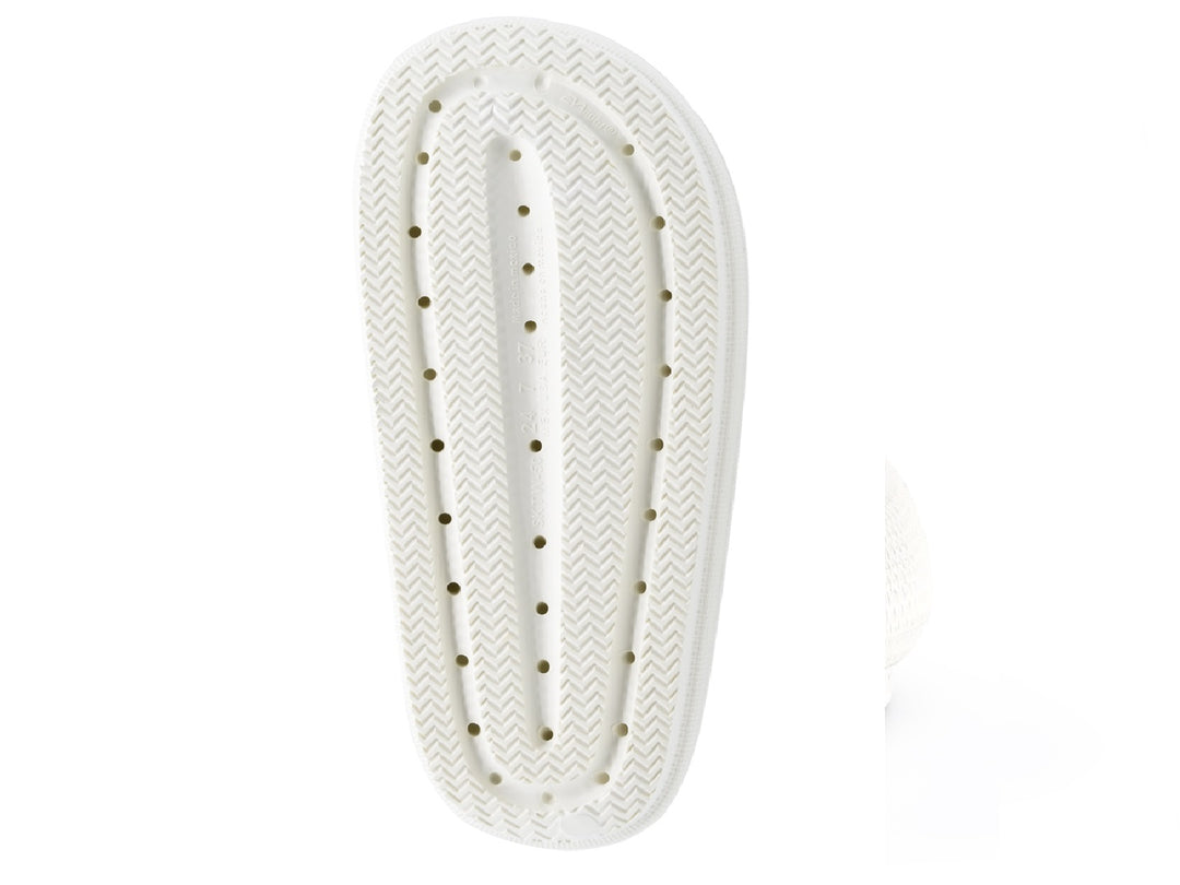 Sandalias blancas para mujer con dos tiras anchas y suela texturizada sobre fondo blanco.