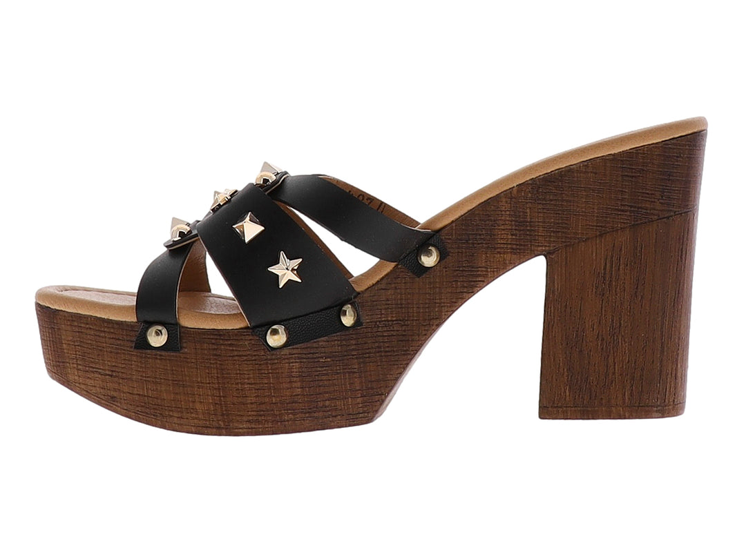 Sandalia negra de plataforma con tacón grueso de madera y adornos de estrellas doradas en las correas.