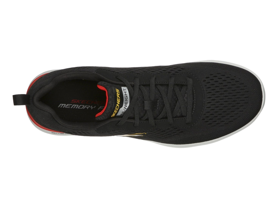Tenis deportivos Skechers color negro con suela blanca y detalle rojo para hombre.