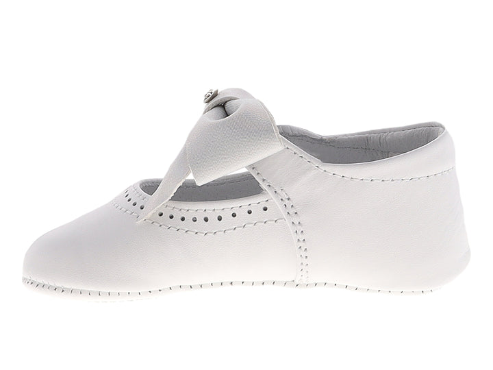 Zapato blanco para bebé estilo Mary Jane con moño decorativo y detalles perforados.