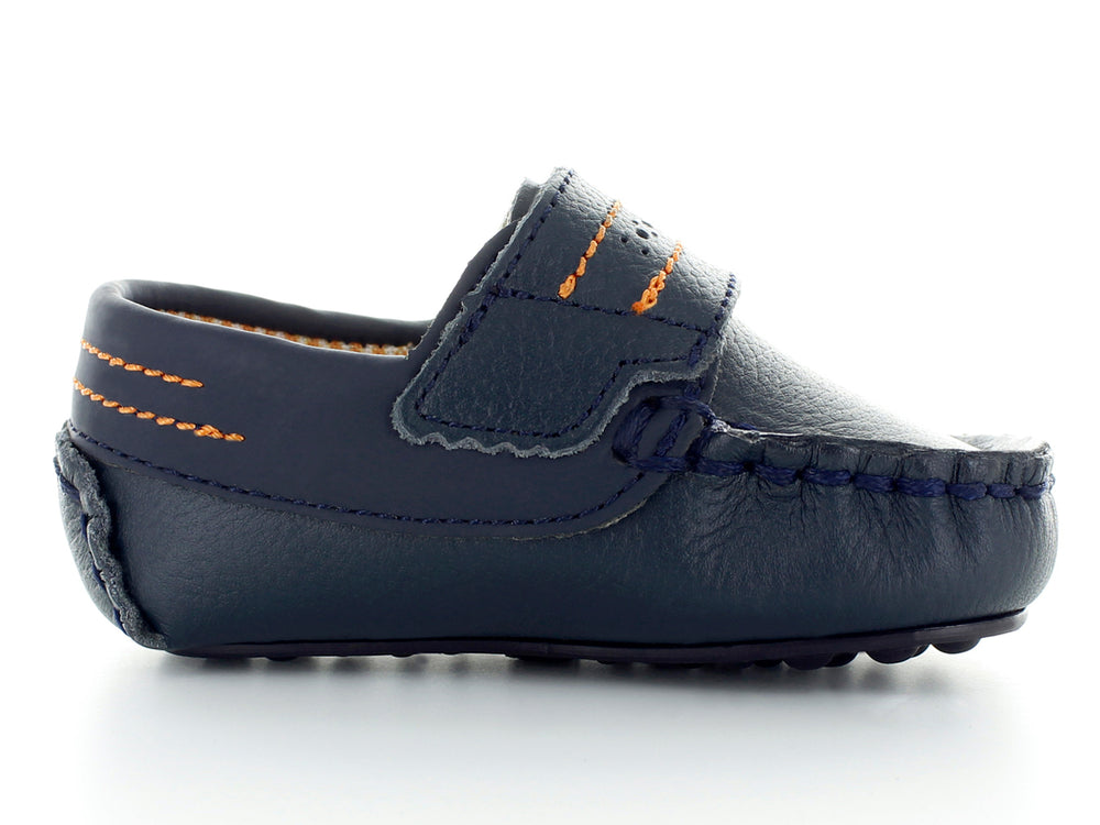 Par de zapatos tipo mocasín color azul marino para bebé con costuras decorativas en naranja y hebilla plateada.