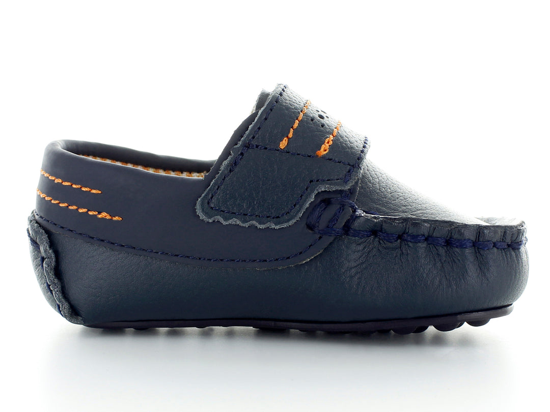Par de zapatos tipo mocasín color azul marino para bebé con costuras decorativas en naranja y hebilla plateada.