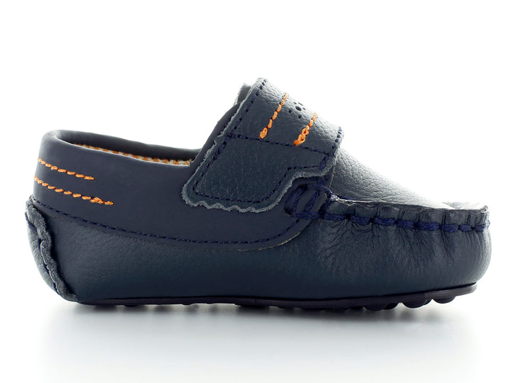 Par de zapatos tipo mocasín color azul marino para bebé con costuras decorativas en naranja y hebilla plateada.