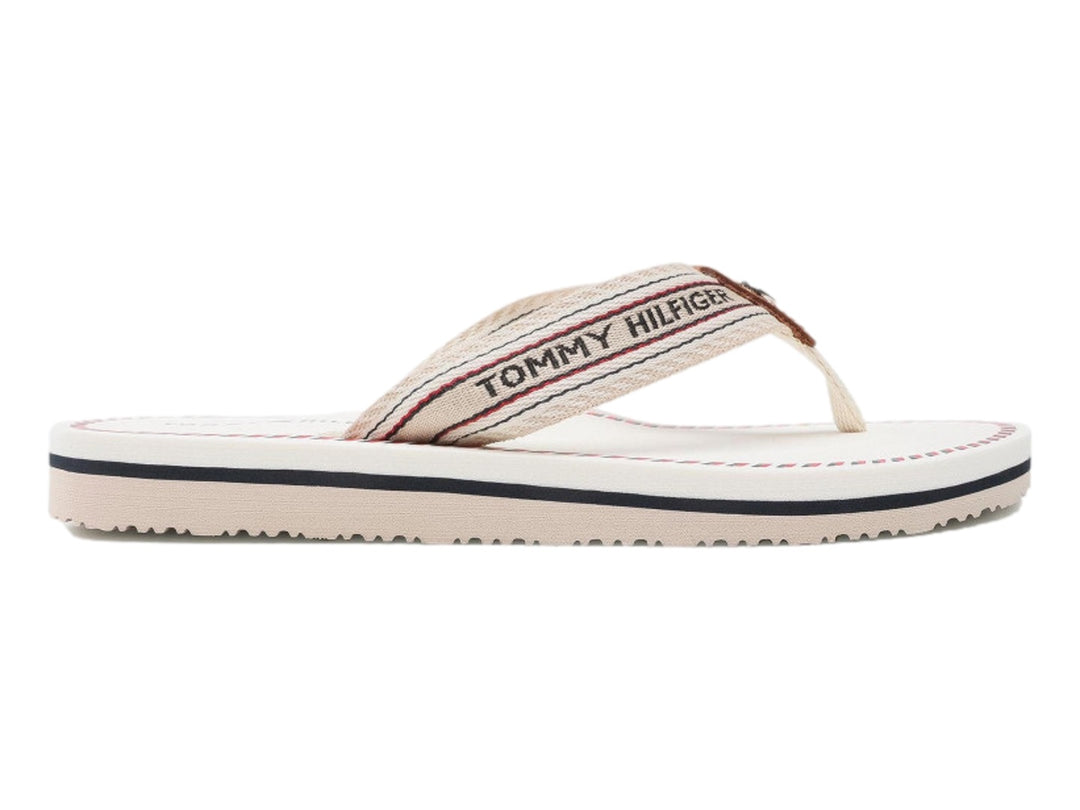 Sandalias planas Tommy Hilfiger color ecru con correa de rayas y suela blanca con detalle azul.