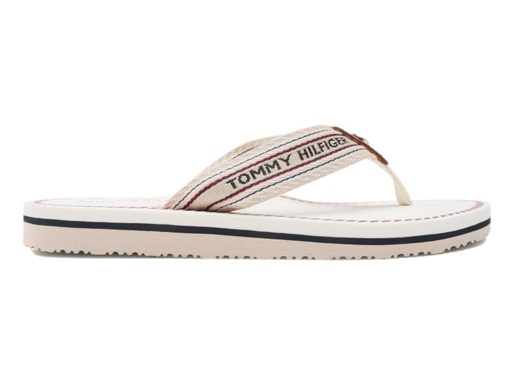 Sandalias planas Tommy Hilfiger color ecru con correa de rayas y suela blanca con detalle azul.
