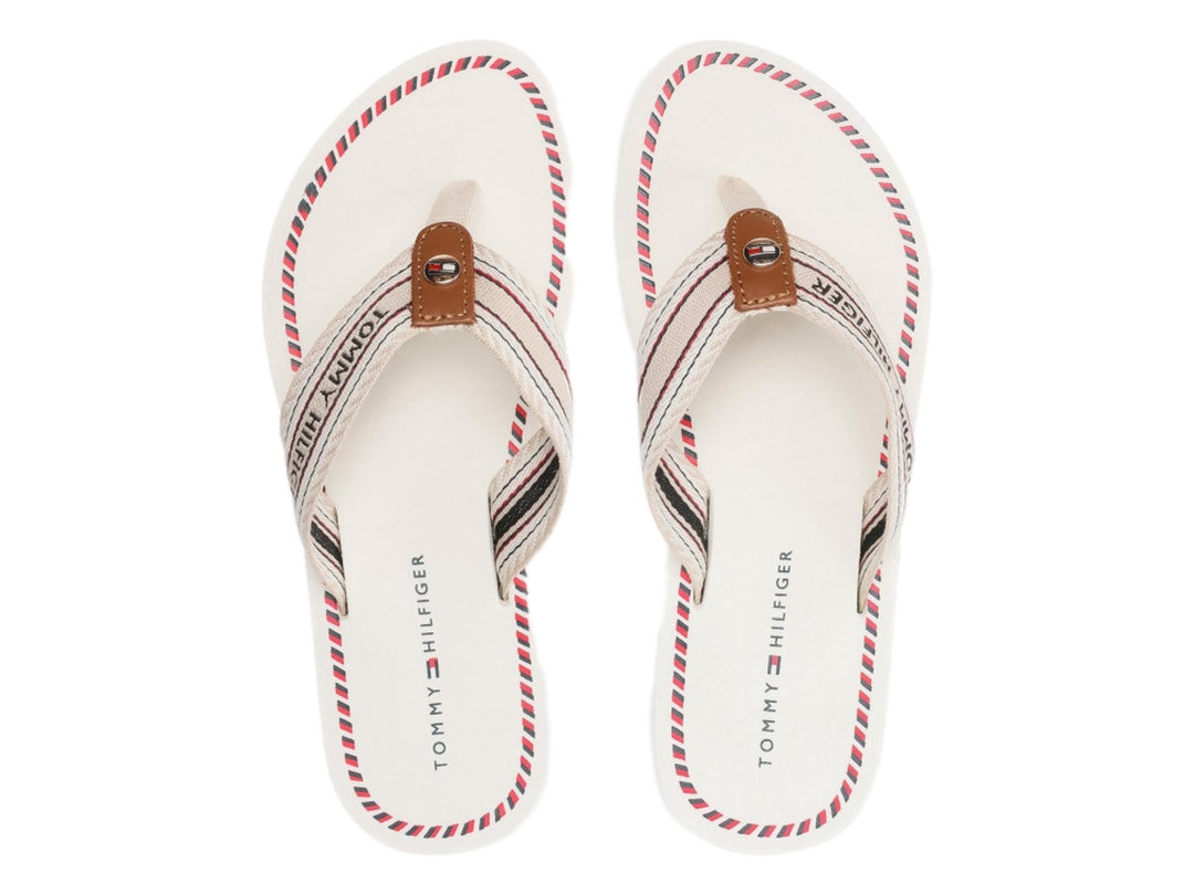 Sandalias planas Tommy Hilfiger color ecru con correa de rayas y suela blanca con detalle azul.