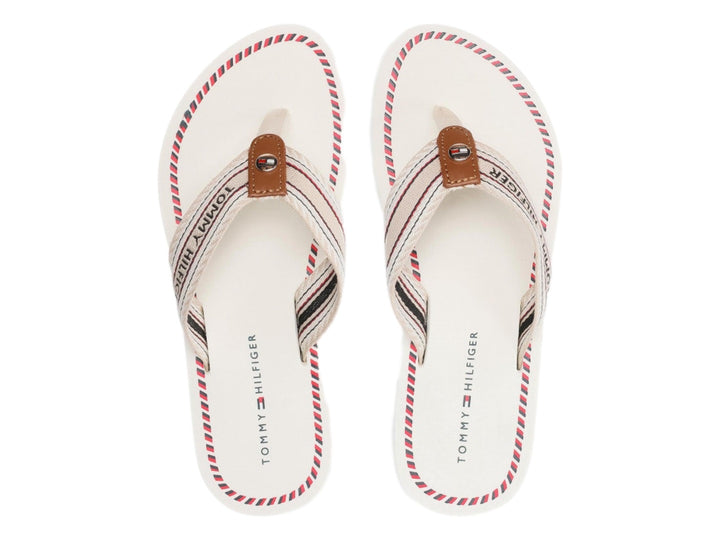 Sandalias planas Tommy Hilfiger color ecru con correa de rayas y suela blanca con detalle azul.