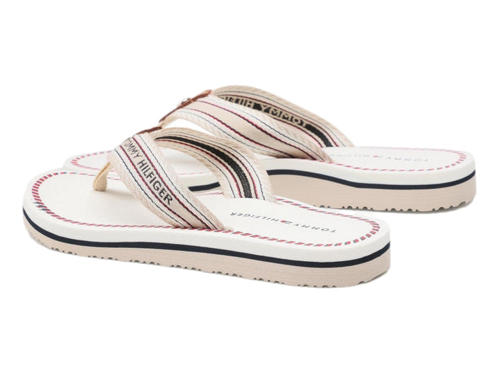 Sandalias planas Tommy Hilfiger color ecru con correa de rayas y suela blanca con detalle azul.