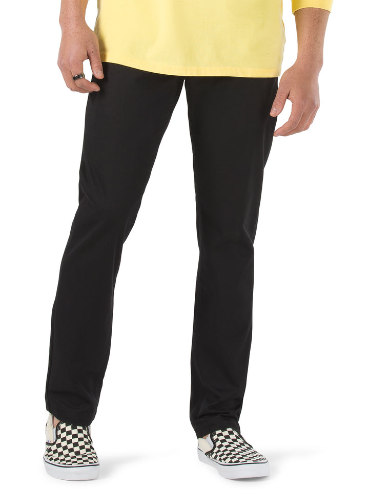 Hombre vistiendo pantalón chino color negro de la marca Vans.