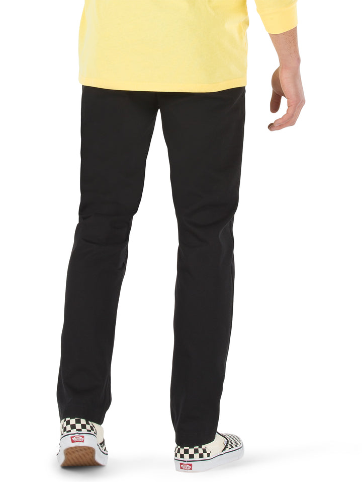 Hombre vistiendo pantalón chino color negro de la marca Vans.