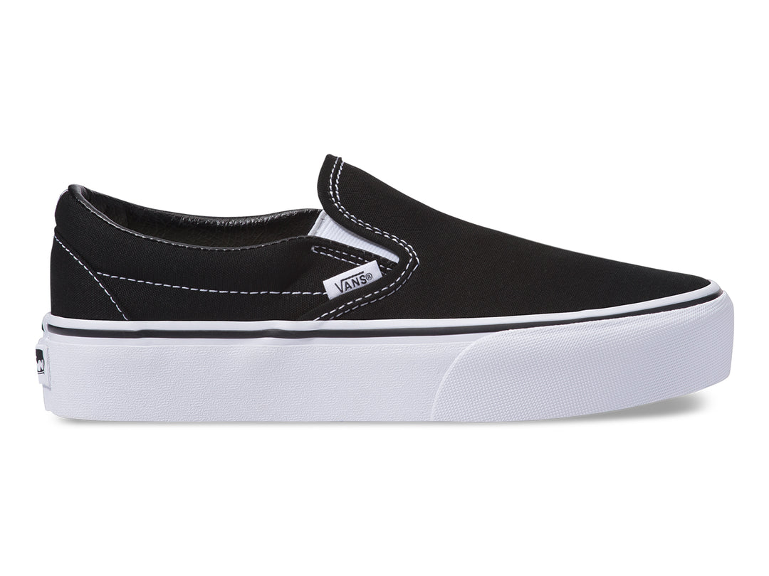 Tenis Vans Slip-On para mujer en color negro con suela blanca.