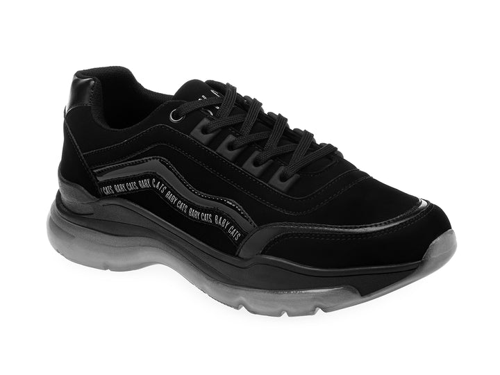 Tenis negros de estilo deportivo con suela gruesa gris translúcida y detalles de texto blanco en el lateral