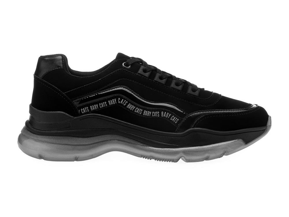 Tenis negros de estilo deportivo con suela gruesa gris translúcida y detalles de texto blanco en el lateral