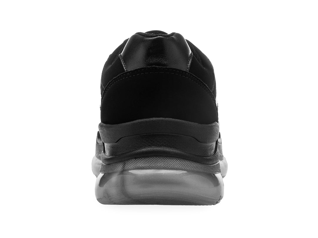 Tenis negros de estilo deportivo con suela gruesa gris translúcida y detalles de texto blanco en el lateral
