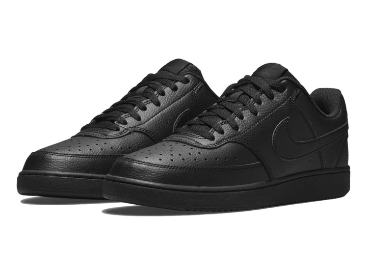 Par de tenis Nike Court Vision Low en color negro sólido, vista lateral.