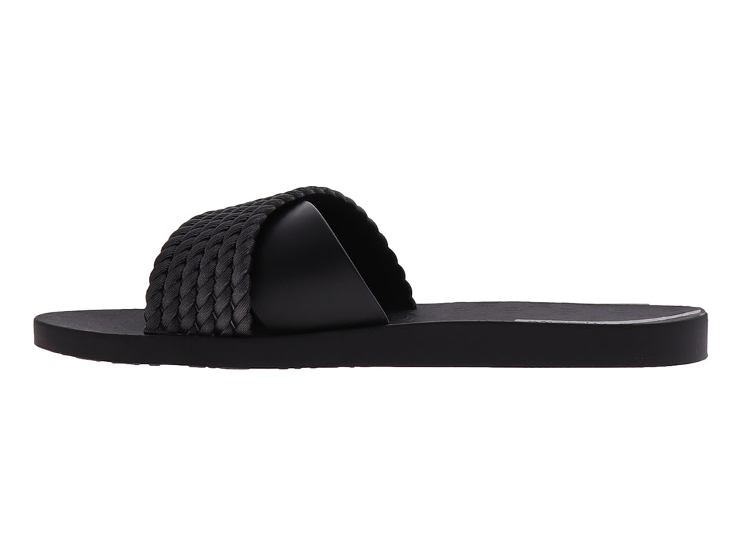 Sandalia Ipanema de color negro con correa superior trenzada y suela plana.