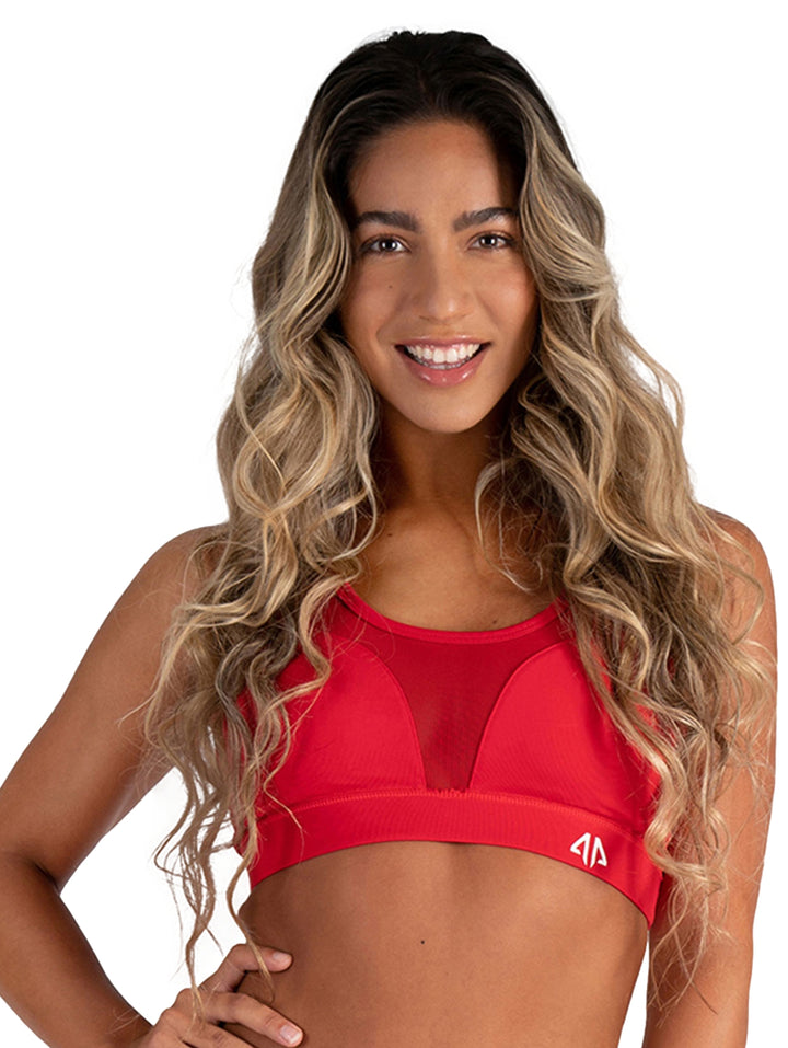 Mujer vistiendo un sujetador deportivo color rojo rubí con paneles de malla.
