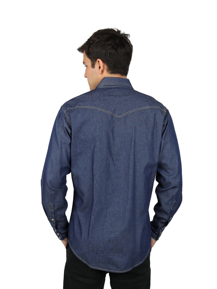 Hombre vistiendo camisa de mezclilla color índigo de manga larga con bolsillos frontales y costuras en contraste.