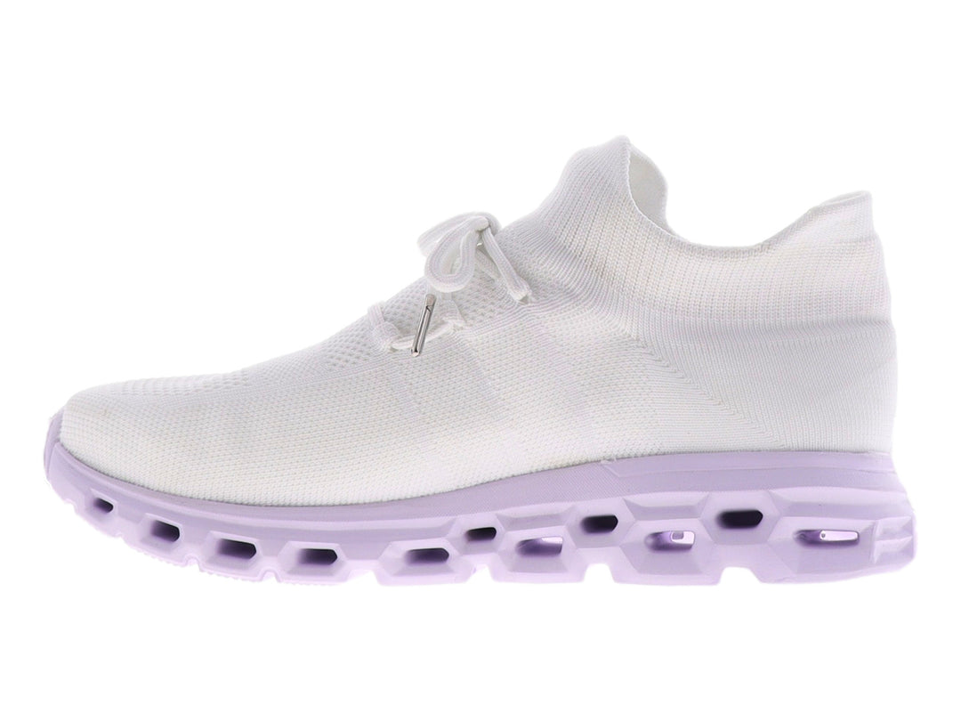 Tenis blancos de tela con suela gruesa color morado claro y diseño perforado.