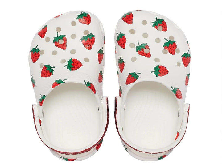 Zuecos Crocs blancos para niña con estampado de fresas y correa roja brillante.